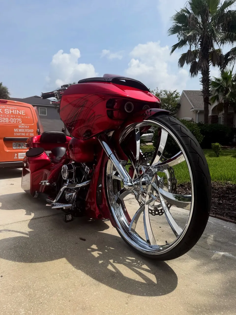 Custom red Harley-Davidson bagger with chrome wheels after a Slick Shine detail