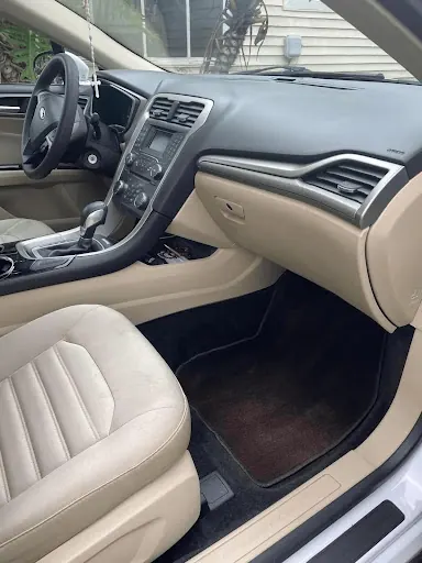 After: the same sedan with a clean dashboard and floor mat