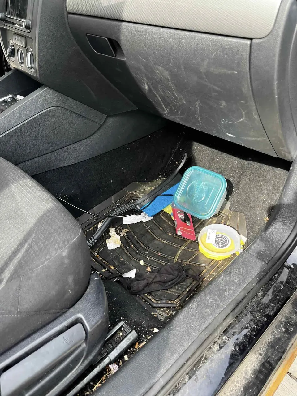 Before: passenger floor with trash, a food container and debris